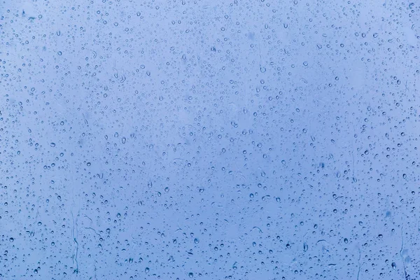 Esik az eső egy üveg, színes háttérrel — Stock Fotó