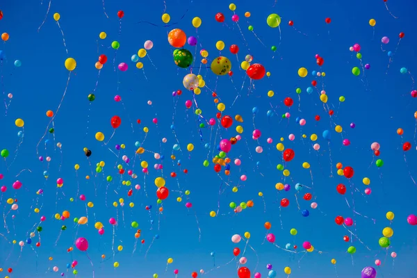 Globos multicolores vuelan en el cielo azul —  Fotos de Stock