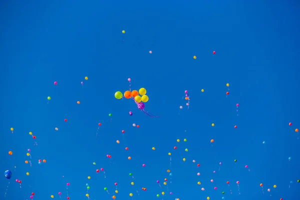 Kolorowe balony latają w błękitne niebo — Zdjęcie stockowe