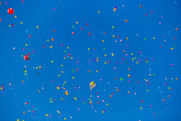 Balões multicoloridos voam no céu azul — Fotografia de Stock