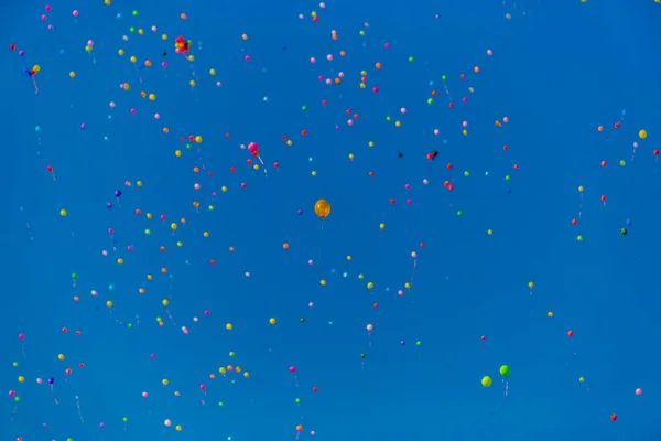 Kolorowe balony latają w błękitne niebo — Zdjęcie stockowe