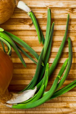 Yeşil taze soğan bir kesim ahşap tahta üzerinde yatıyor