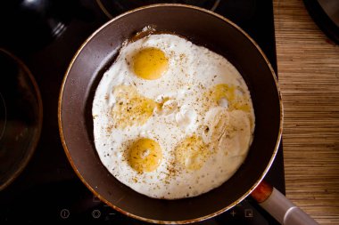 Bir tavada evde soba üzerinde yumurta pişirme