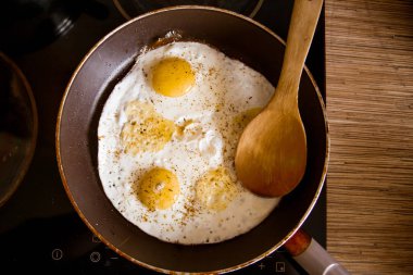 Bir tavada evde soba üzerinde yumurta pişirme