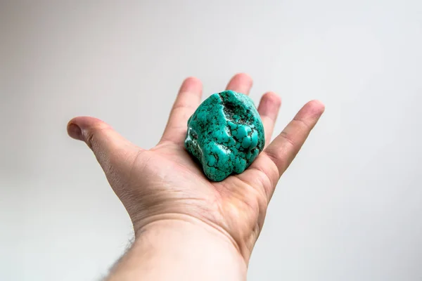 Sten blå turkos ligger på en långsträckt hand — Stockfoto
