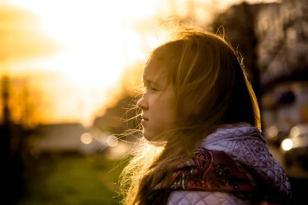 Menina olhando para a distância ao pôr do sol — Fotografia de Stock