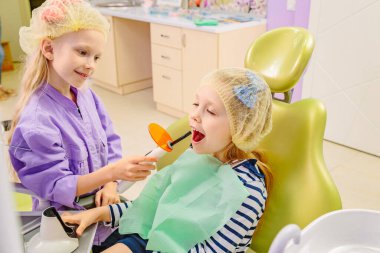 Çocuklar dişçi ofisinde oynarlar.
