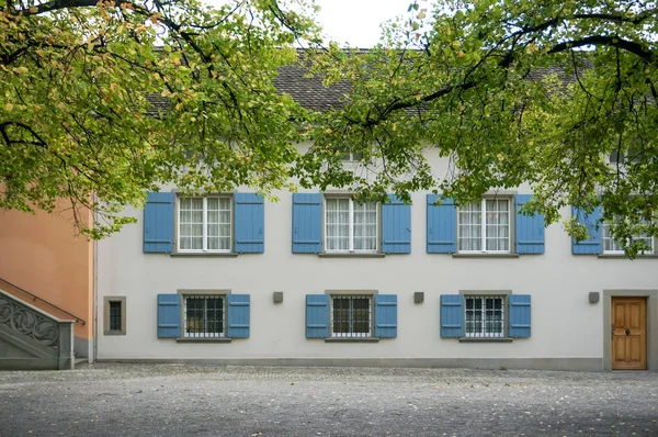 Vista de janelas abertas edifício pastel vintage com árvore verde em — Fotografia de Stock