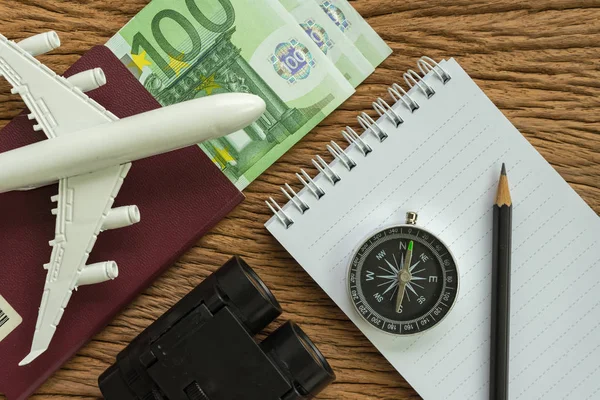 Travel planning concept with airplane, passport, compass, binocu