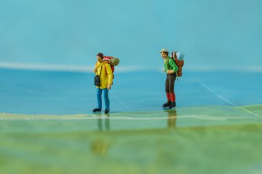 Arka plan olarak harita üzerinde yürüyen minyatür backpackers concep seyahat
