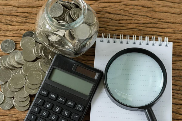 Flat lay of magnifying glass on white note book paper and calcul