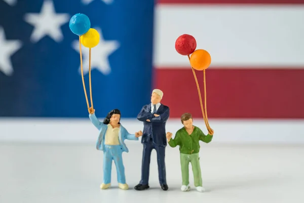 Glad amerikansk miniatyr figur familjen hålla ballonger med Uni — Stockfoto