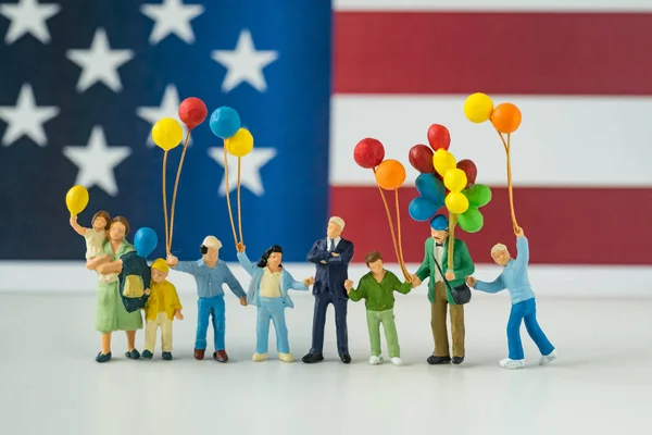 Miniaturní šťastná rodina drží balónky s Spojených státu národa — Stock fotografie