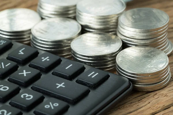 Enfoque selectivo en la calculadora con pila de monedas en el backgro — Foto de Stock