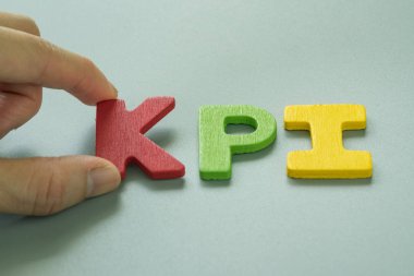 Renkli ahşap alfabe KPI tutan el