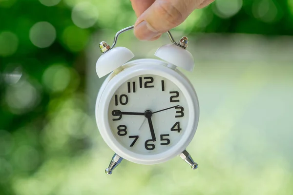 Mano celebración de reloj despertador blanco como negocio o tiempo de cuenta atrás con — Foto de Stock