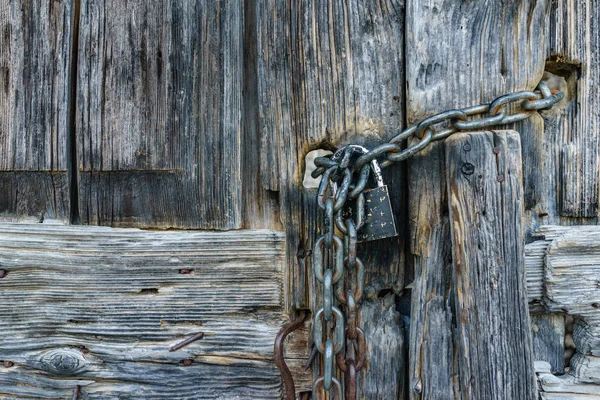 Catena arrugginita invecchiata con blocco pad sulla vecchia porta in legno antico — Foto Stock