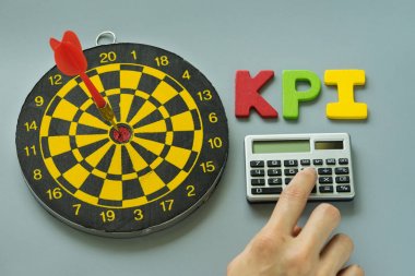 hesap makinesi ve renkli alfabesi KPI dart tahtası ile parmak olarak