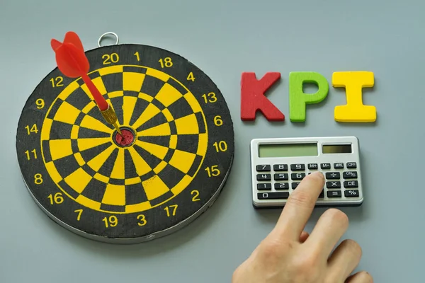 hesap makinesi ve renkli alfabesi KPI dart tahtası ile parmak olarak