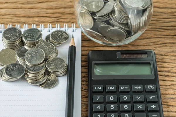 Enfoque selectivo en pila de monedas con lápiz y cuaderno, calculadora como concepto de ahorro financiero — Foto de Stock