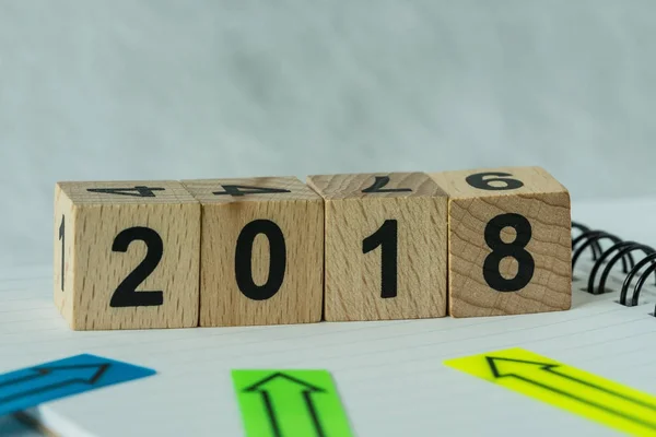 Messa a fuoco selettiva su blocco cubo in legno con numero 2018 con freccia — Foto Stock