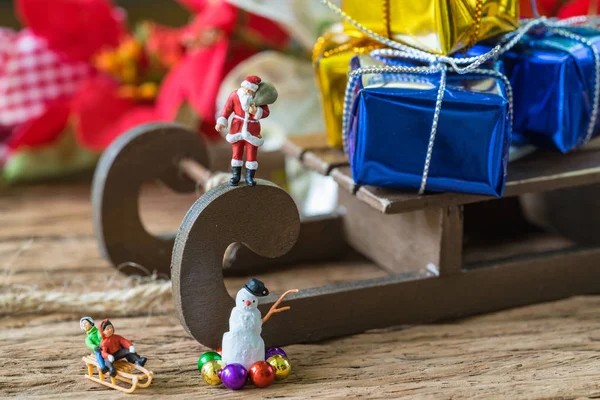 Figura miniatura de Santa Claus de pie en trineo con gran regalo — Foto de Stock