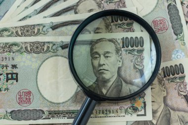 Büyüteç Japonya yen banknot olarak finansal yığını üzerinde veya 