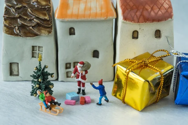 Figura miniatura de Santa Claus dando regalo a los niños felices wi — Foto de Stock
