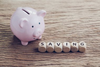 Gülümseyen pembe domuz kumbarası ya da tahta küp bloklu bozuk para bankası