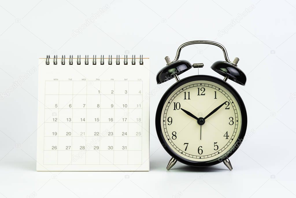 White clean calendar with black retro alarm clock on white backg