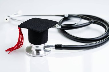 Graduation hat on doctor stethoscope, white background using as 