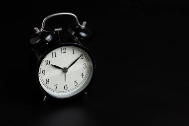 Black retro alarm clock in dark black bedroom with copy space us