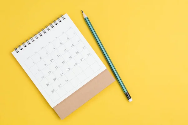 白色干净的日历 背景为纯黄 带有铅笔和复制空间 商务会议规划 旅行时间表或项目里程碑和提醒概念 — 图库照片