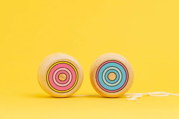 Wooden Yoyo 장난감은 노란색 배경에 공간을 사용하여 자산의 가격의 위험성으로 — 스톡 사진