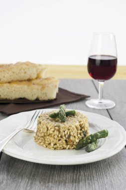 Ahşap masa üzerinde seramik tabak içinde kuşkonmaz ile risotto