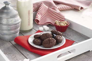 Rustik bisküvi çikolata ve fıstık bir bottl ile ahşap tepsi