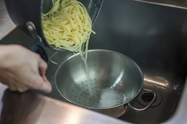 Su boşaltma işlemi sırasında spagetti ile pota Stok Fotoğraf