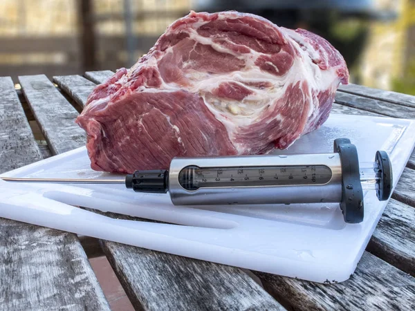 Costeleta de porco injetando com seringa de alimentos para cozinhar lentamente na farpa — Fotografia de Stock