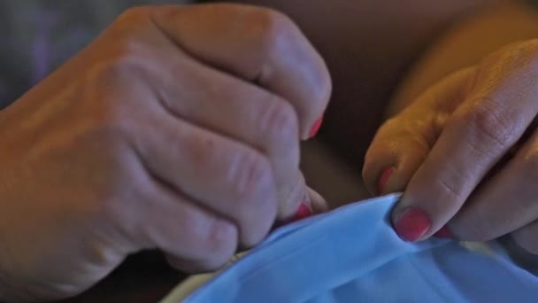 Vrouw naaien blauwe kleding met de hand — Stockvideo