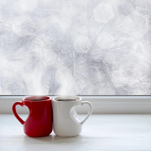 窓枠の上のコーヒーを 2 杯。クリスマスの背景としてウィンドウに冷ややかなパターンを背景に — ストック写真