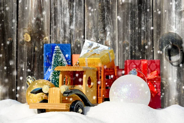 Natale background.Toy camion con regali, abete di Capodanno e palle nella neve — Foto Stock