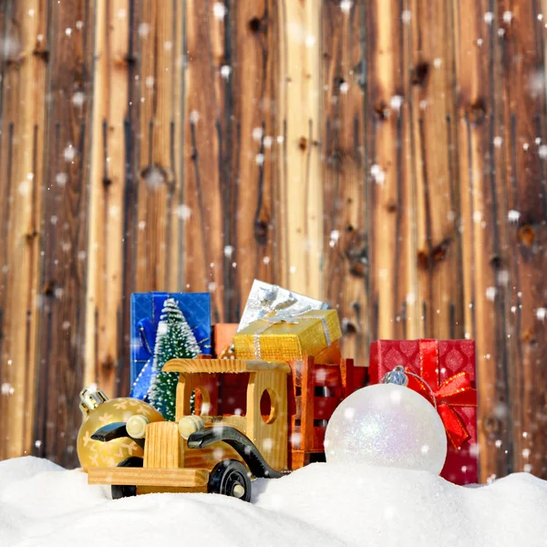 Boże Narodzenie tła. Ciężarówka Zabawka z prezenty, jodła nowy rok i kulki w śniegu — Zdjęcie stockowe