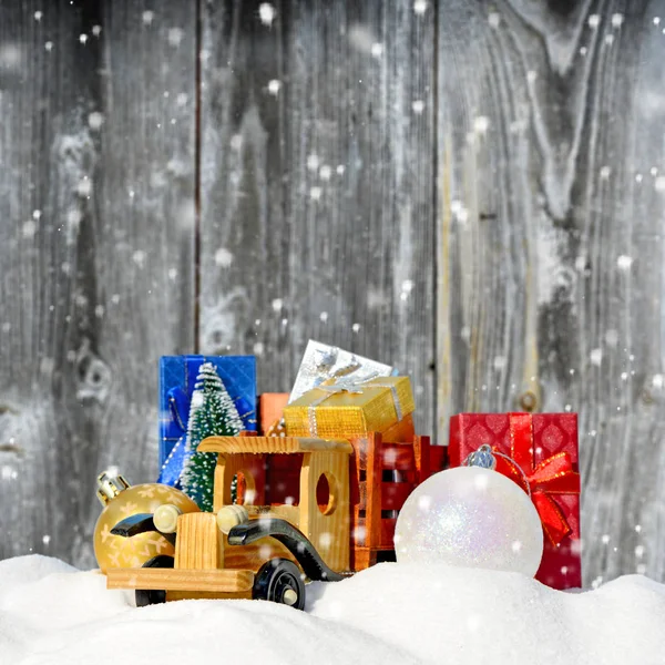 Natale background.Toy camion con regali, abete di Capodanno e palle nella neve — Foto Stock