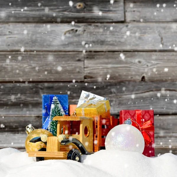 Natale background.Toy camion con regali, abete di Capodanno e palle nella neve — Foto Stock