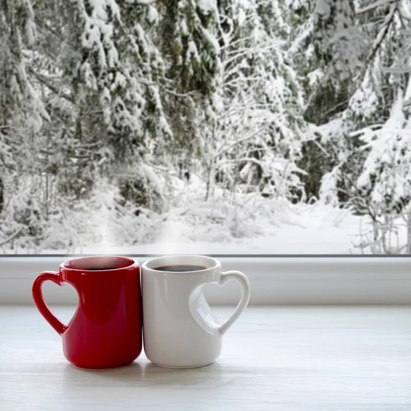 两杯咖啡在窗台上。在背景中，一个美丽的冬天森林里雪 — 图库照片