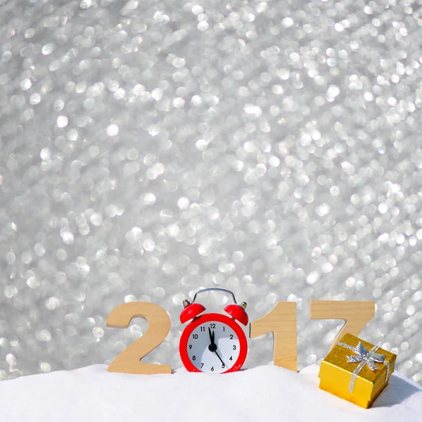 Feliz año nuevo 2017 fondo de saludo. Números 2017 y despertador en una deriva de nieve sobre un fondo bokeh plata — Foto de Stock
