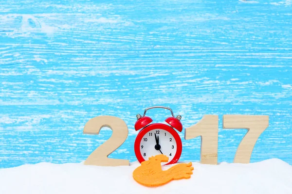 Gallo, símbolo de 2017 en el calendario chino. Gallo y los números 2017 en una deriva de nieve sobre un fondo de madera azul — Foto de Stock