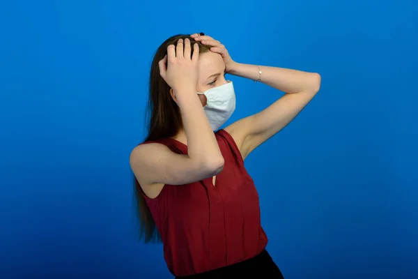 Girl in protective medical mask and blue gloves on blue background. close-up portrait of a woman in a transparent mask. way to protect against coronavirus. Covid-2019, Pandemic 2020