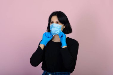 Mavi renkli koruyucu yüz maskesi takan beyaz kız. Kameraya bakan kız. virüs ve kirlilik koruma kavramı.