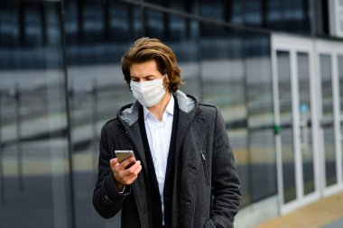 Dışarıda tıbbi maskeli genç adam, para yok, kriz, yoksulluk, zorluk, yalnızlık.